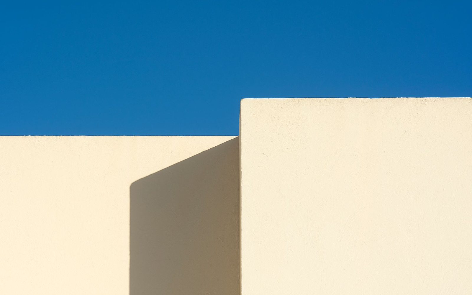 Strakke geometrische vlakken tegen een diepblauwe lucht